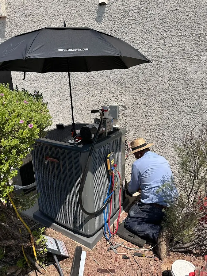 HVAC technician performing outdoor AC maintenance in Sylvania