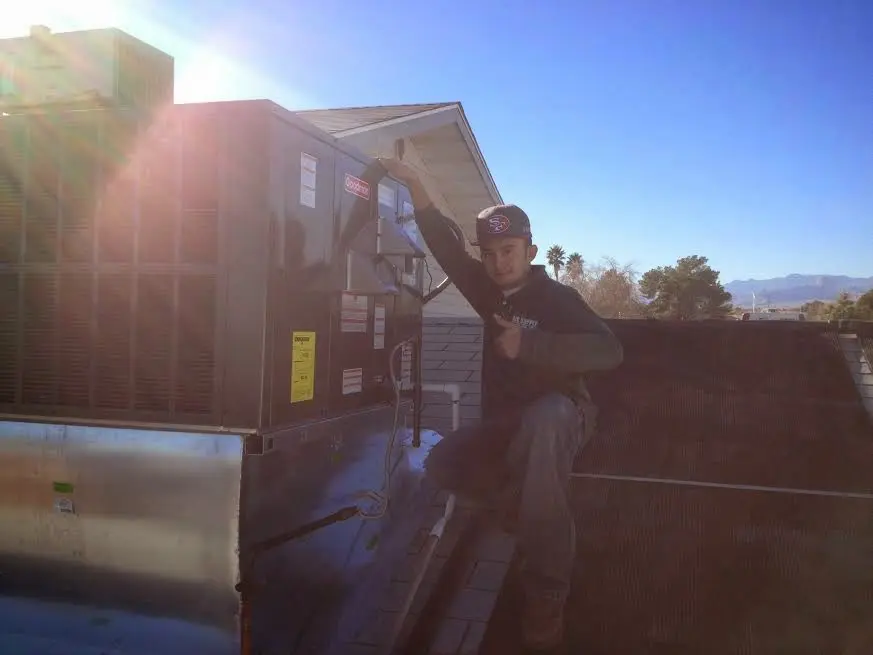 HVAC technician performing AC Tune-Up on a rooftop unit in Sylvania